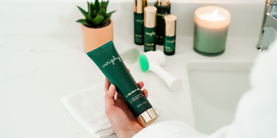 Veriphy Skincare CTRL+ALT+DEL Facial Cleanser in green recyclable squeeze tube with gold cap laying down on marble surround